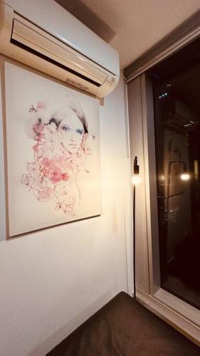 a painting of a woman on a wall next to a window at Nest Apartments on Rose Lane in Melbourne