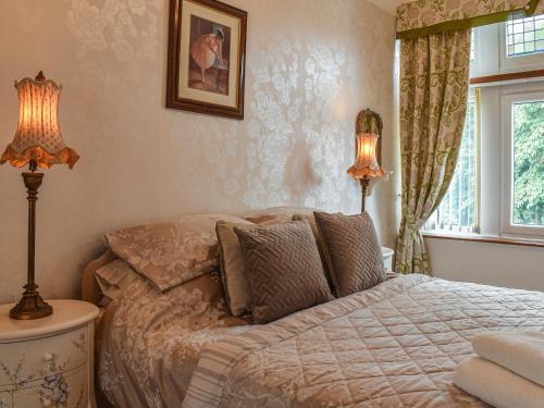a bedroom with a bed with two lamps and a window at The Haven in Heysham