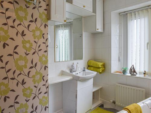 uma casa de banho com um lavatório e um espelho em The Haven em Heysham