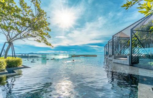una piscina con el océano en el fondo en Edge Central PATTAYA SeaView Residence en Pattaya centro