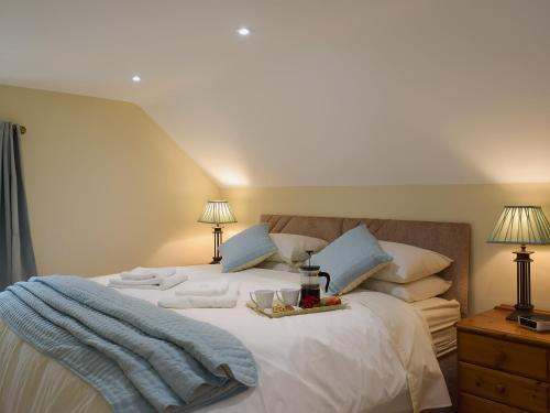 Un dormitorio con una cama con una bandeja de comida. en Gardeners Lodge en Pembroke