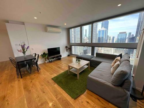 a living room with a couch and a large window at Nest Apartments on Rose Lane in Melbourne