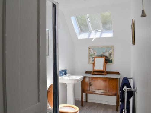 een badkamer met een wastafel, een toilet en een spiegel bij The Courtyard Suite in Oathlaw