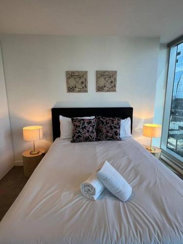 a bedroom with a white bed with two towels on it at Nest Apartments on Rose Lane in Melbourne