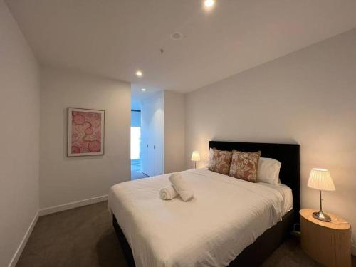 a bedroom with a large white bed with two lamps at Nest Apartments on Rose Lane in Melbourne