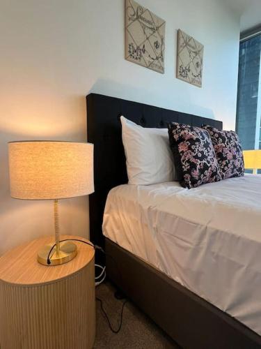 a bedroom with a bed with a lamp next to it at Nest Apartments on Rose Lane in Melbourne