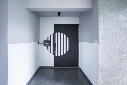 a hallway with a black door in a building at Grey Stone - Lakefront PentHouse Family Rooms in Kolhapur