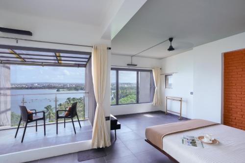 a bedroom with a bed and a large window at Grey Stone - Lakefront PentHouse Family Rooms in Kolhapur