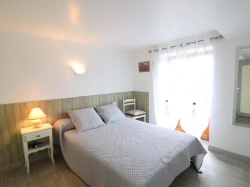 ein Schlafzimmer mit einem weißen Bett und einem Fenster in der Unterkunft Gîte Vitrac, 3 pièces, 4 personnes - FR-1-742-450 in Vitrac