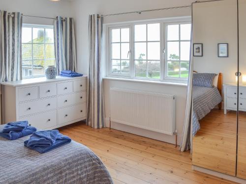 a bedroom with two beds and a mirror at Lyndale in Penzance