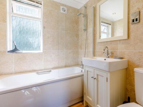 ein Badezimmer mit einem Waschbecken, einer Badewanne und einem WC in der Unterkunft Nanny Goat Lodge in Crossway Green
