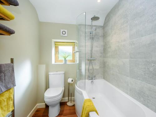 uma casa de banho com uma banheira branca e um WC. em Stackyard Cottage em Felmingham