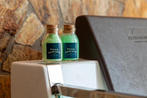 two glass bottles sitting on top of a refrigerator at Villa Toscana - Vale dos Vinhedos in Bento Gonçalves