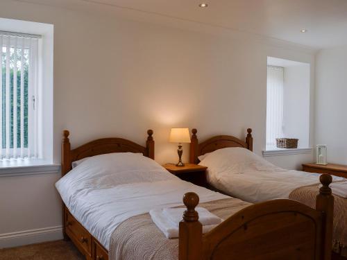 twee bedden in een kamer met twee ramen bij Kirroughtree Steading 1 - Uk5859 in Newton Stewart