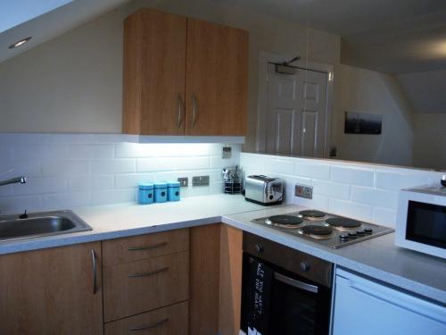 a kitchen with a sink and a stove top oven at Niddry Street Apartments Edinburgh in Edinburgh