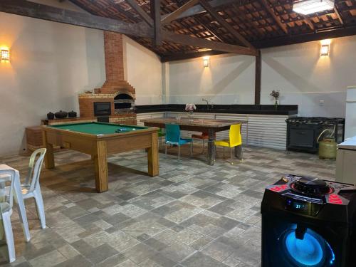 a room with a ping pong table and chairs at Casa de praia Le Frute. Mar, piscina, descanso! in Vila Velha