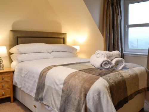 a bedroom with a bed with towels on it at Liftingstane Farmhouse in Closeburn