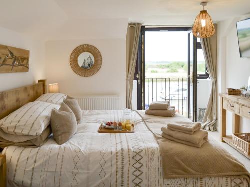 a bedroom with a bed with a tray of food on it at Riverbank Cottage in Reedham