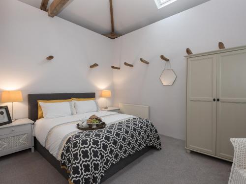 a bedroom with a bed with a tray of food on it at Heron Barn in Little Hautbois