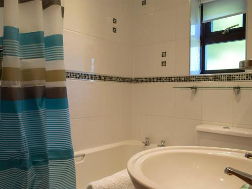 a bathroom with a tub and a sink at The Byre in Lympsham