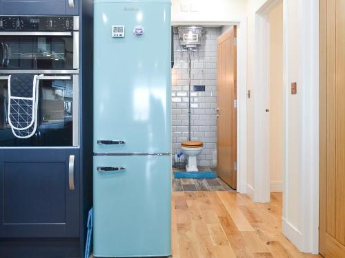 a blue refrigerator in a kitchen with a toilet at 4 Dolphins in Connel