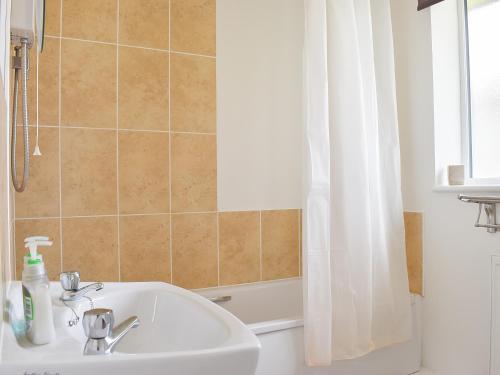 a bathroom with a sink and a shower curtain at Mallard Cottage - Uk33872 in Cote