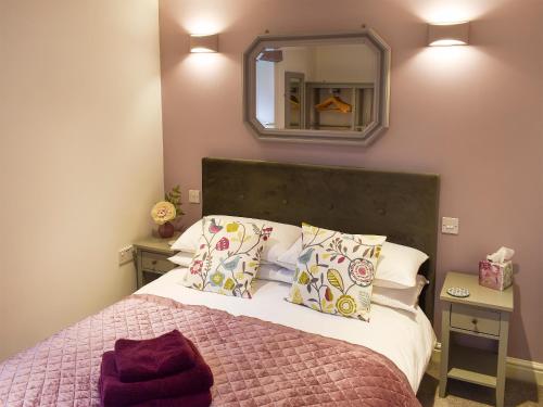 a bedroom with a bed and a mirror on the wall at Owls Rest in Burley in Wharfedale