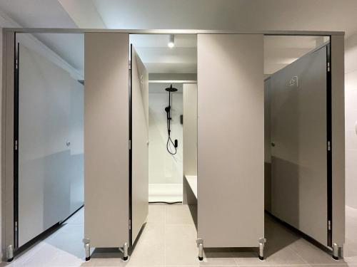 a row of glass doors in a hallway at Airone Capsule Hotel in Hobart