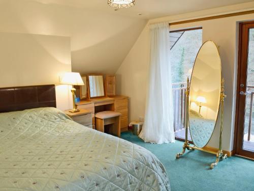 a bedroom with a bed and a large mirror at The Wheelhouse in Linlithgow