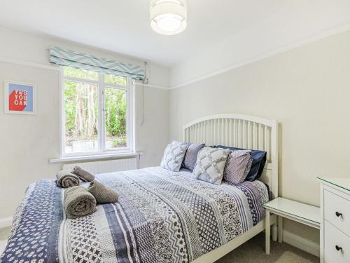 a bedroom with a bed and a window at West Brae in Bishops Tawton