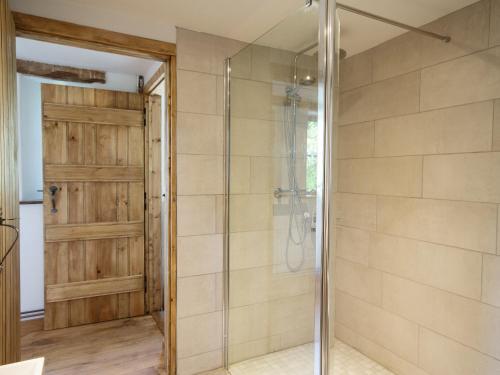 a bathroom with a shower and a glass door at The Cider Barn in Flaxley