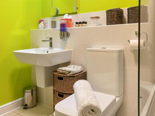 a bathroom with a toilet and a sink at Cosy Cotswolds Townhouse in Honington