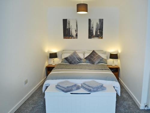 a bedroom with a white bed with two night stands at No2 The Neuk in Belford