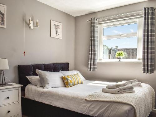 ein Schlafzimmer mit einem Bett mit einem Fenster und einem Fenstersitz in der Unterkunft 10 Castaway-uk45095 in Kessingland