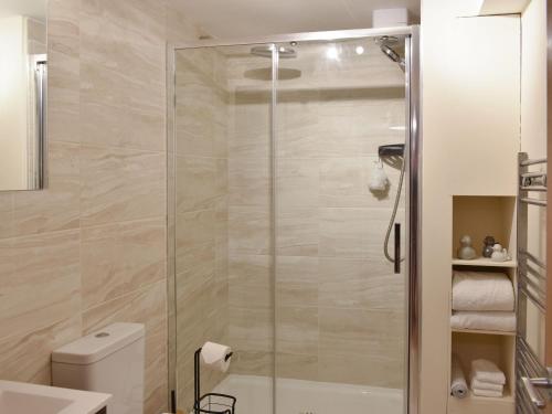 W łazience znajduje się prysznic ze szklanymi drzwiami. w obiekcie The Mews w mieście Appleby