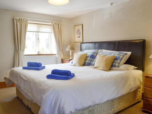 - une chambre avec un grand lit et des serviettes bleues dans l'établissement Woodland View-uk11826, à Llandefaelogfâch
