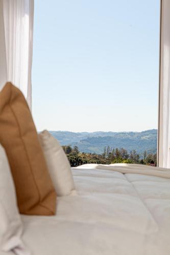 a white couch sitting in front of a window at Villa Toscana - Vale dos Vinhedos in Bento Gonçalves