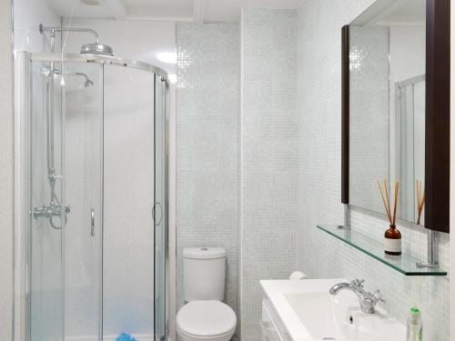 a bathroom with a shower and a toilet and a sink at Percy Park Apartment in Tynemouth