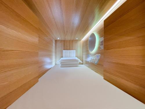 ホバートにあるAirone Capsule Hotelの木造キャビン内のベッド1台が備わる小さな客室です。
