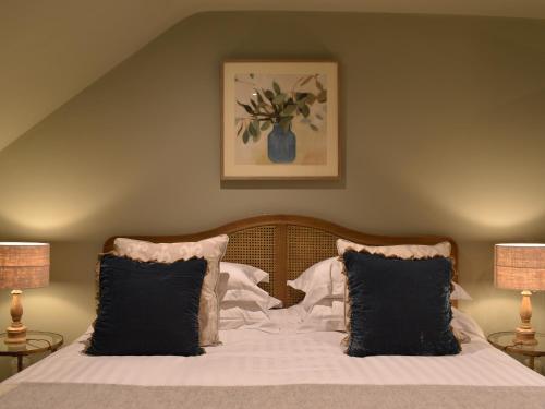 a bedroom with a bed with black and white pillows at Larkhams Loft in Teffont Magna