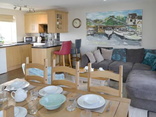 a kitchen and living room with a table and chairs at Davids Island in Wroxham