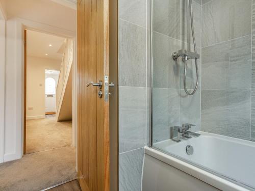 a bathroom with a shower and a bath tub at Broadacre House in Brixham