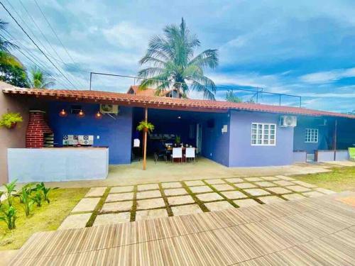 瓜拉帕里的住宿－Casa_praia_Laphina - Frente do mar com piscina!，蓝色的房子,前面设有一个露台