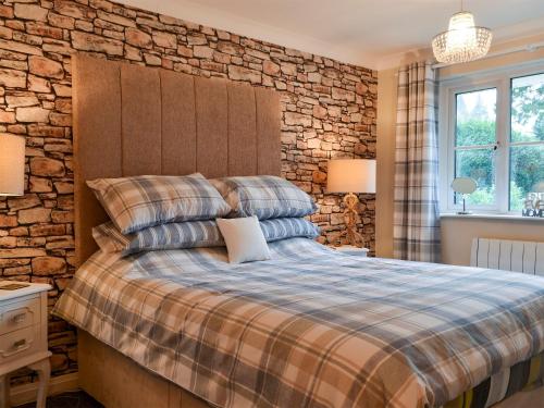 a bedroom with a bed and a stone wall at Bowness Retreat in Bowness-on-Windermere