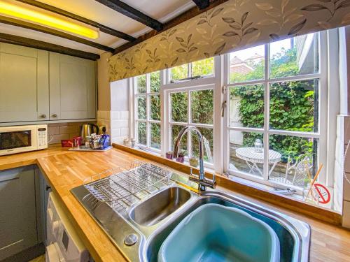 a kitchen with a sink and a large window at Quince Cottage in Saint Michaels
