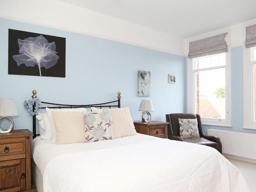a bedroom with a large white bed and a chair at Hamilton House in Royal Tunbridge Wells