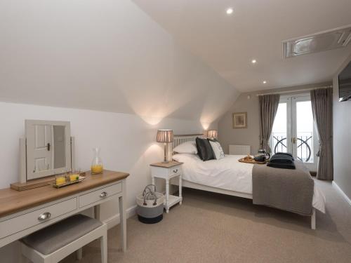 1 dormitorio con cama, escritorio y ventana en River Quay, en Gorleston-on-Sea