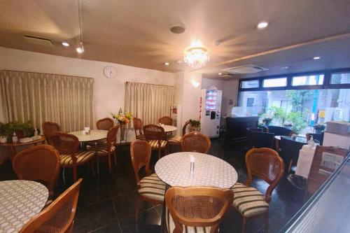 jadalnia ze stołami i krzesłami oraz restauracja w obiekcie E Hotel Warabi w mieście Warabi