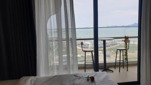 a bedroom with a bed and a view of the ocean at Citadines House - seaview & balcony - studio apartment in Ha Long