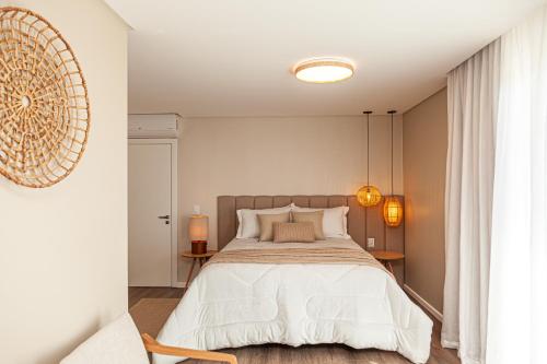 a bedroom with a large bed with white sheets at Villa Toscana - Vale dos Vinhedos in Bento Gonçalves